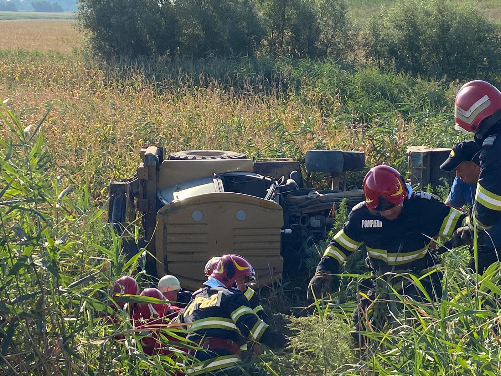 TULCEA/FOTO: Buldoexcavator răsturnat. Două persoane au fost prinse în interiorul cabinei